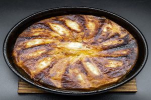 名物の鉄なべ餃子！一口サイズの餃子を鉄なべで焼き上げます。お好みでお召し上がりください。<br />
<br />
【鉄なべ餃子】<br />
1人前 330円(税込) ※2人前より